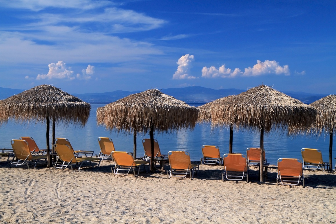 'Greece. Kos island. Tigaki beach.Two chairs and umbrella on the white sand beach' - Κως
